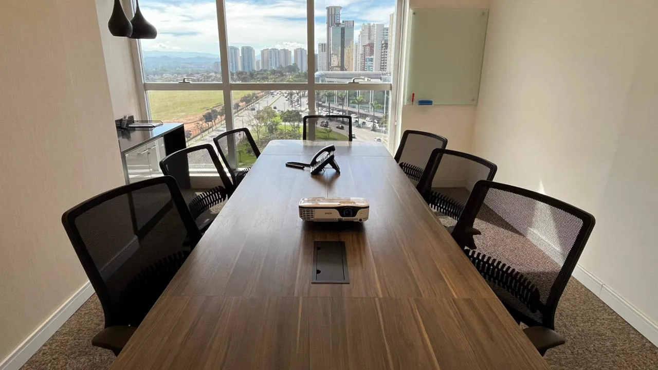 Sala de reunião com projetor e vista para a avenida